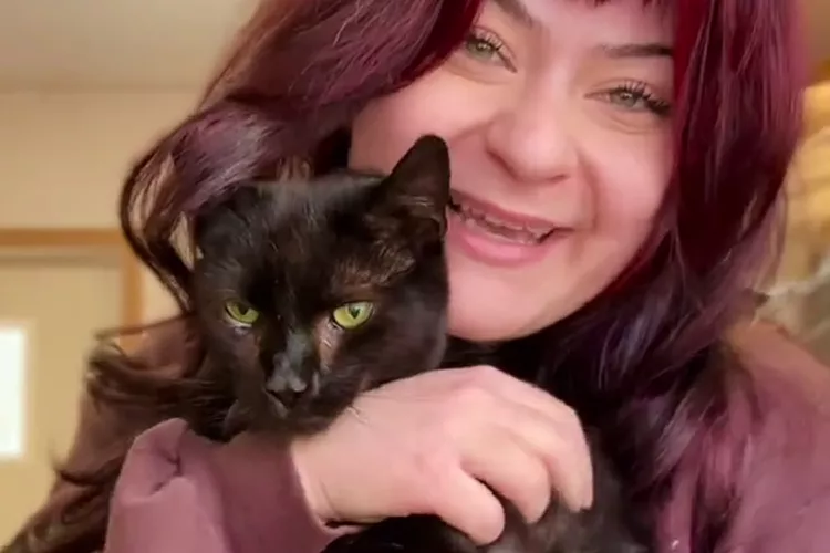 Happy woman holds a black cat