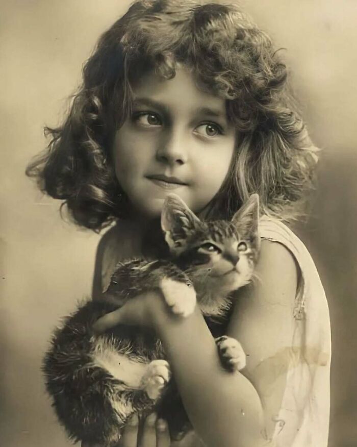Vintage photograph of a young girl holding a kitten