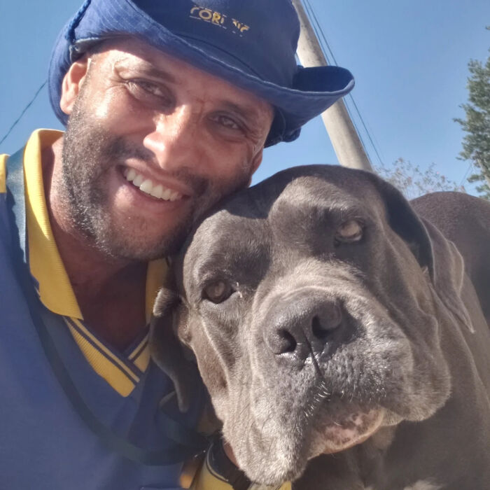 A happy bearded man poses next to a dog